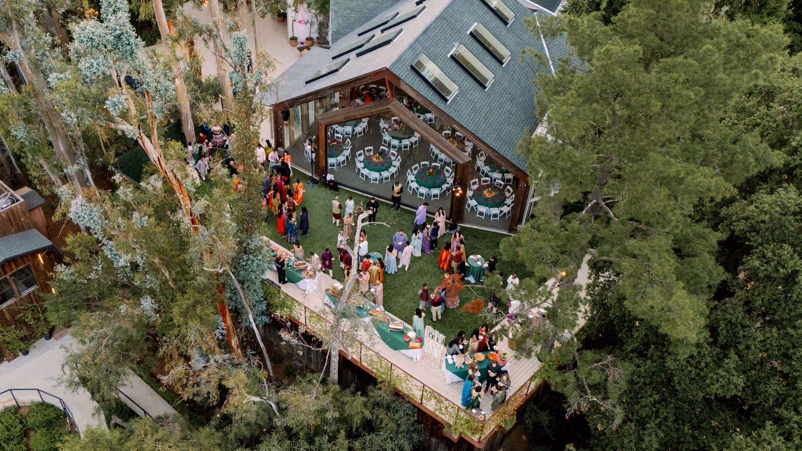 An aerial view of a wedding venue with connected indoor and outdoor gathering spaces