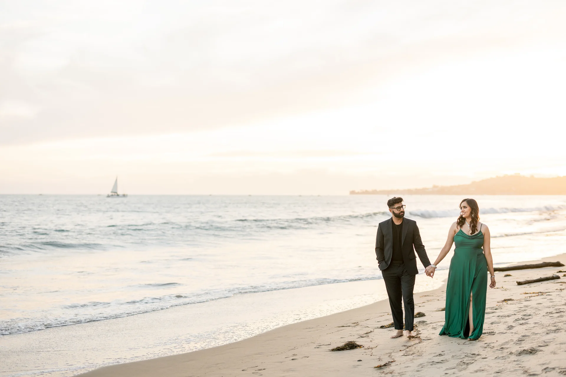 Arpita and Varad walking hand in hand beside the Southern California coast