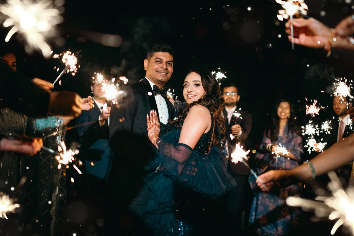 Purna and Mayur together at night, framed by sparklers