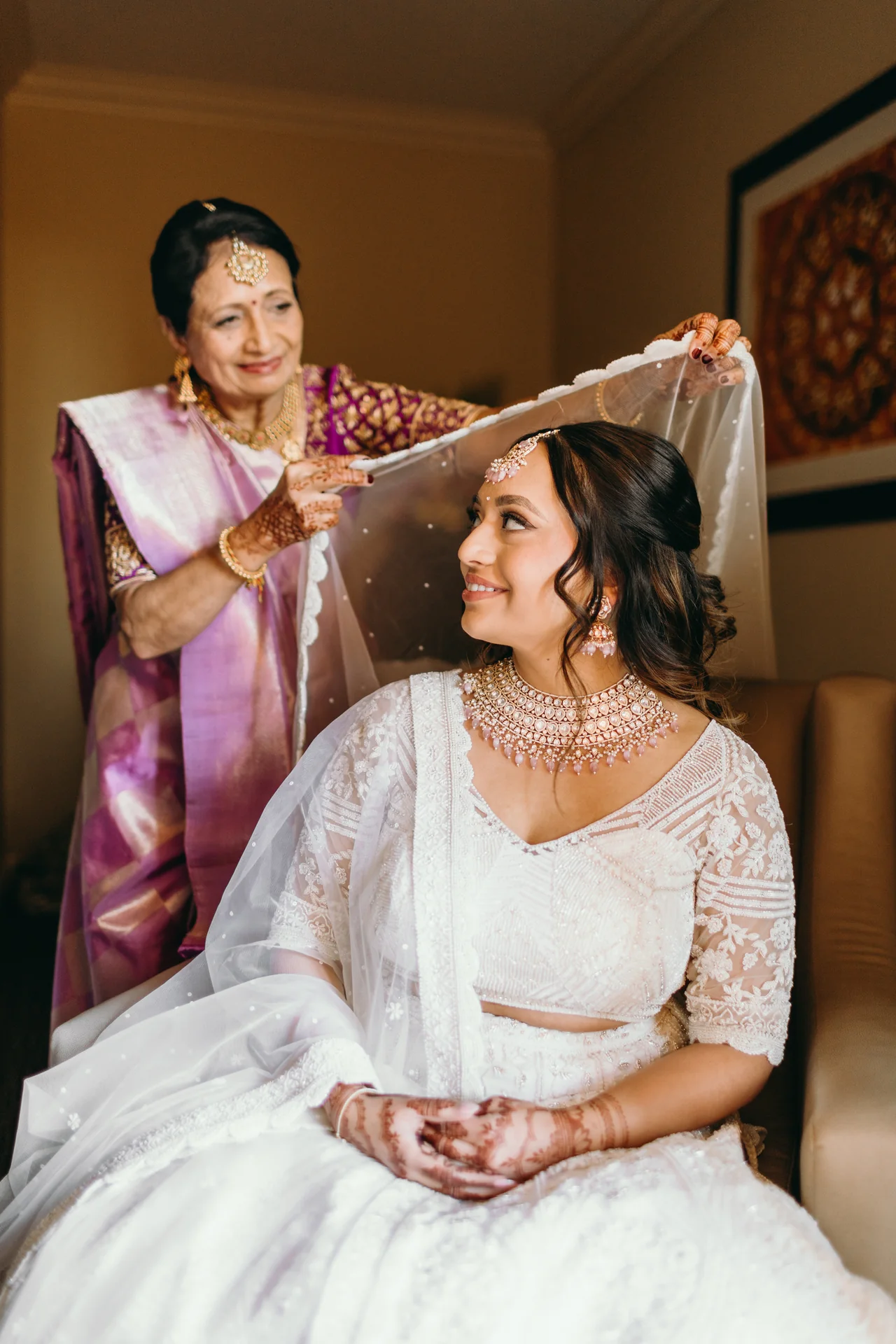 Purna sharing a quiet smile as her veil is arranged