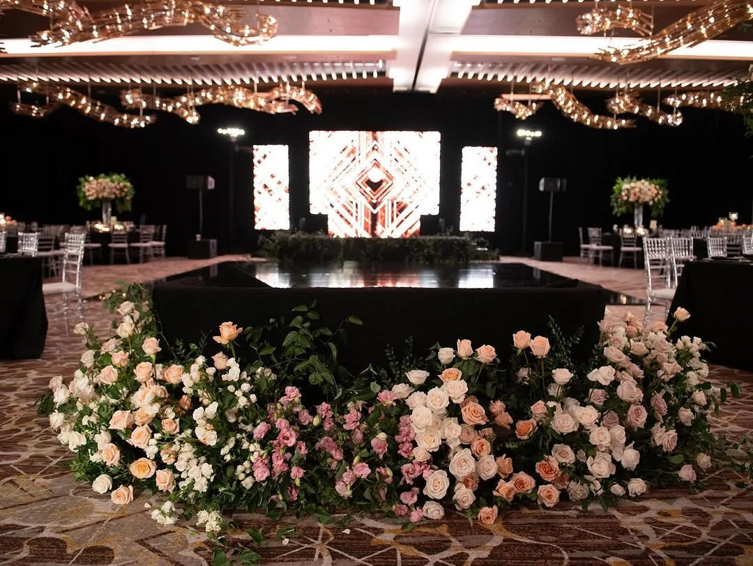 Natasha & Anish — the reception stage framed by flowers