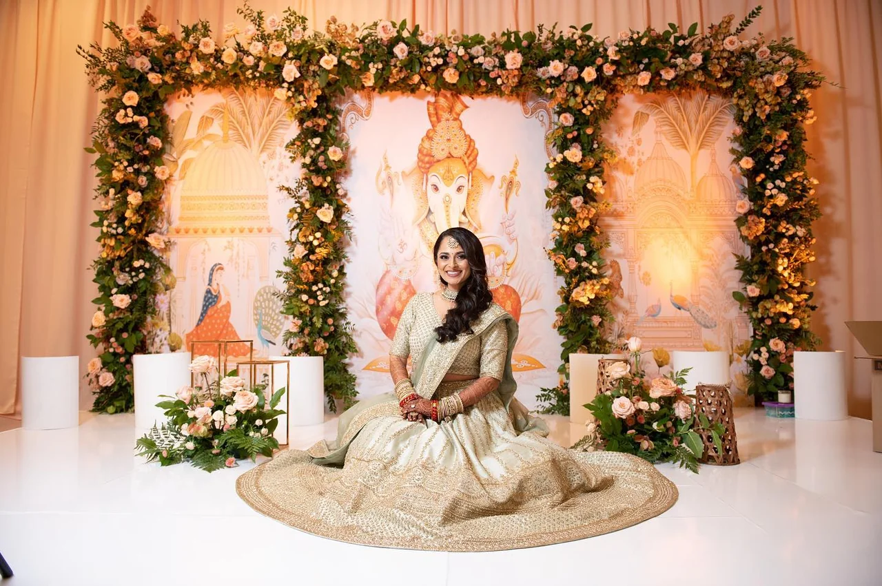 Natasha & Anish — Natasha seated beneath the Grashanti floral backdrop