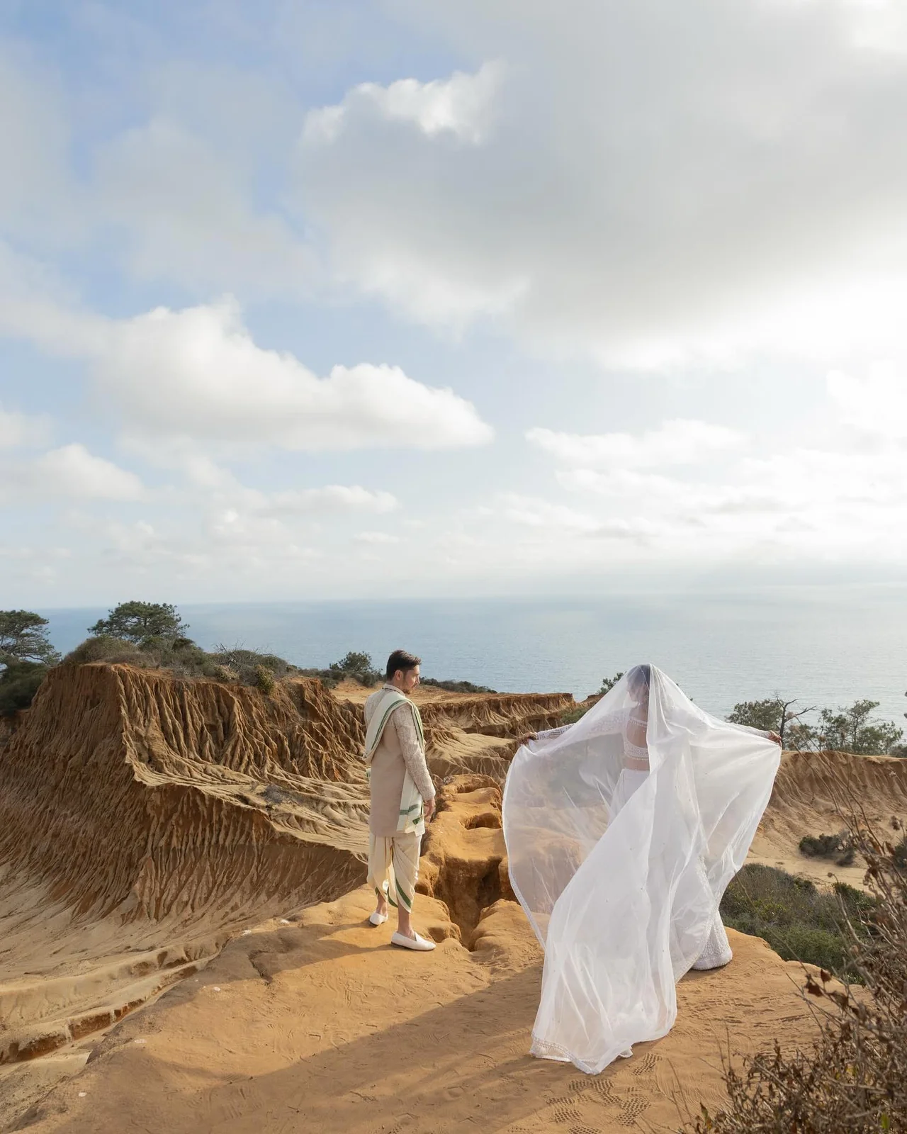 Brisa lifting her veil in the sea breeze as Shakti looks on